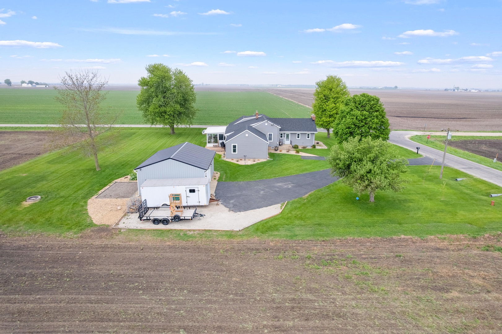 4698 East 17th Road Leland, IL 60531 - Photo 44 of 57 a white house with a yard and a back yard