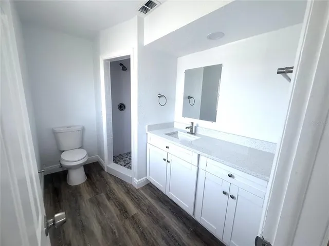 a spacious bathroom with a double vanity sink a toilet and a shower