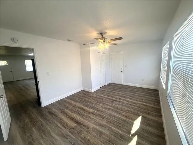 a view of an empty room with wooden floor