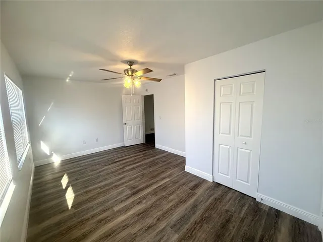 an empty room with wooden floor and entrance