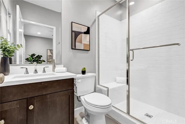 a bathroom with a sink toilet a mirror and shower