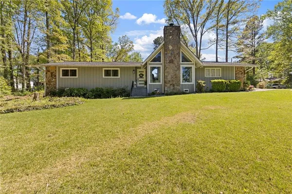 a front view of a house with a yard with trees