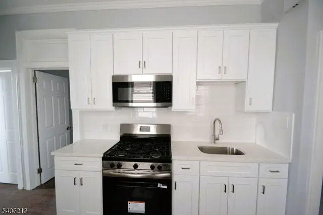 a kitchen with white cabinets and stainless steel appliances