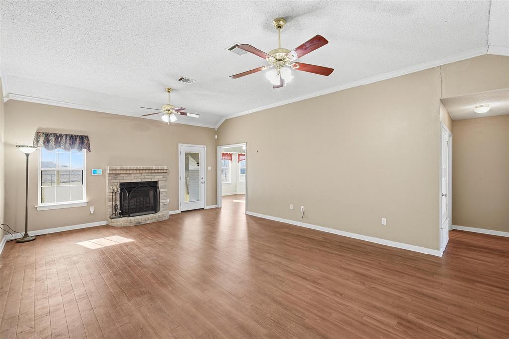 155 Rabajo Road China Spring, TX 76633 - Photo 3 of 40 an empty room with wooden floor chandelier fan and windows