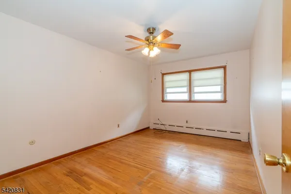 an empty room with a window and a ceiling fan