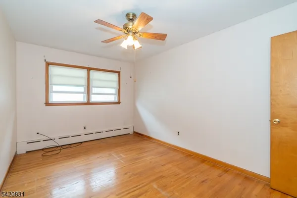 an empty room with a window and wooden floor