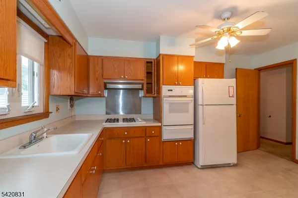 a kitchen with refrigerator a stove a sink and cabinets