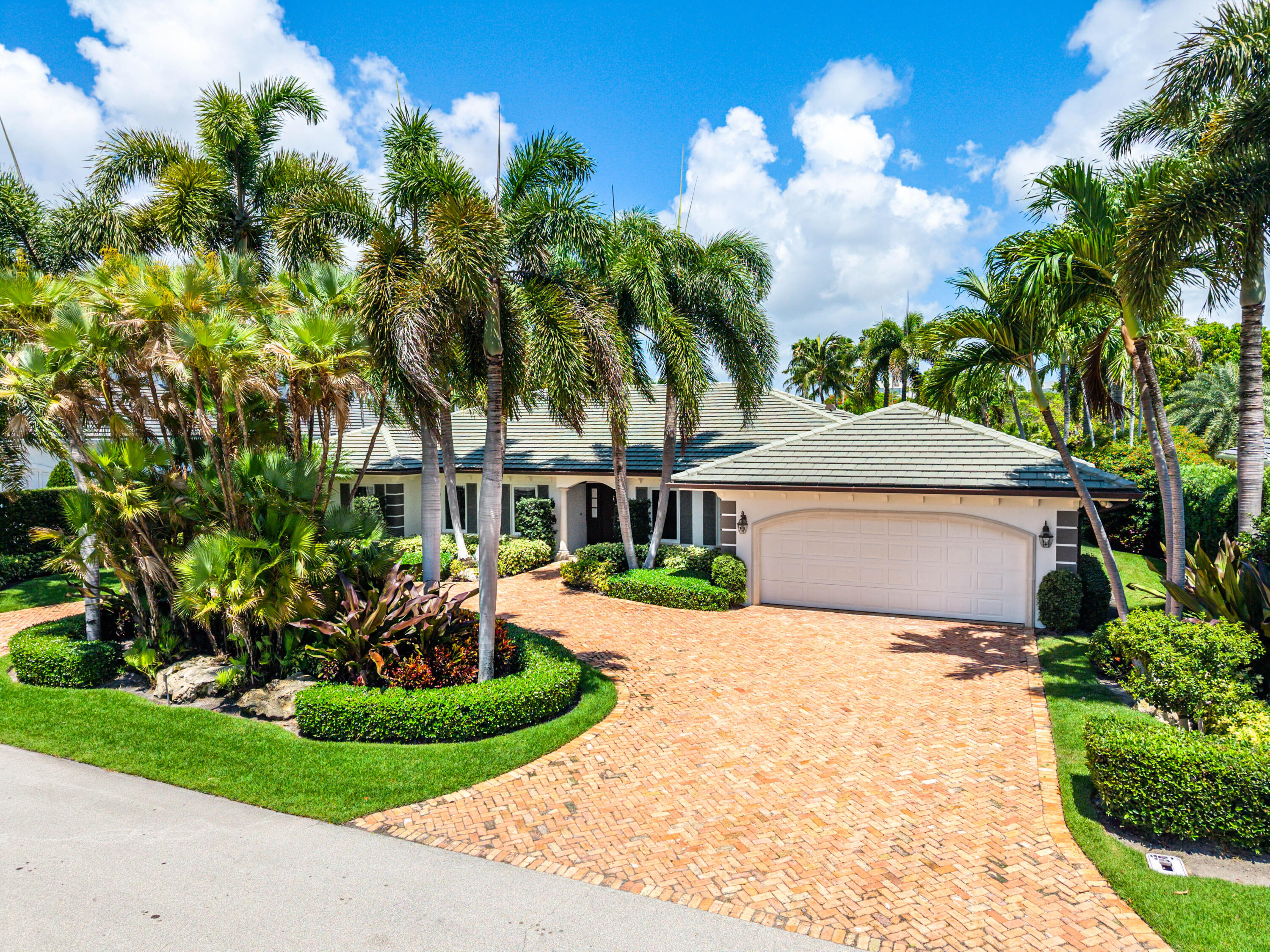 a front view of a house with a yard and potted plants