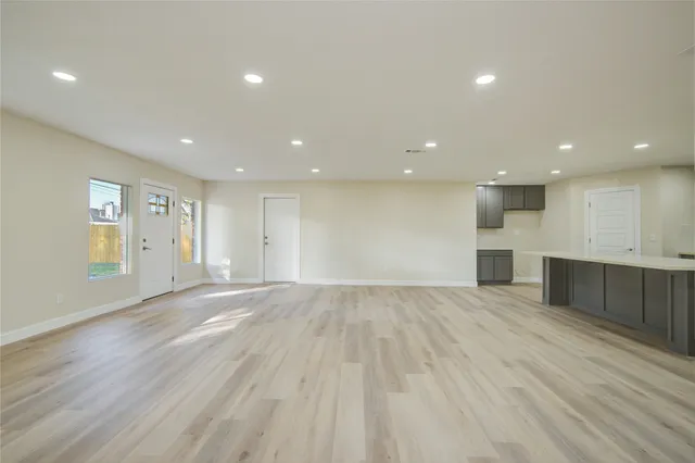 a view of an empty room with wooden floor