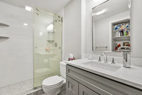 a bathroom with a sink a toilet and shower