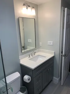 a bathroom with a toilet sink and mirror