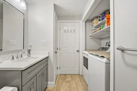 a kitchen with a sink cabinets and wooden floor