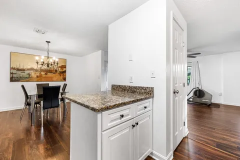 a kitchen with a table chairs and wooden floor