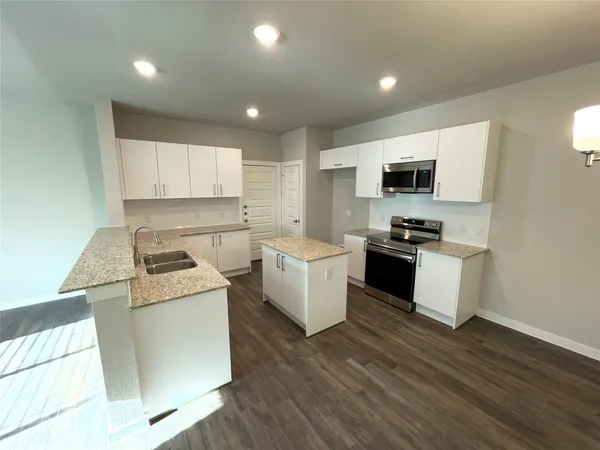 a kitchen with a stove a sink and a microwave
