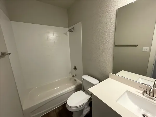a white toilet sitting next to a bath tub