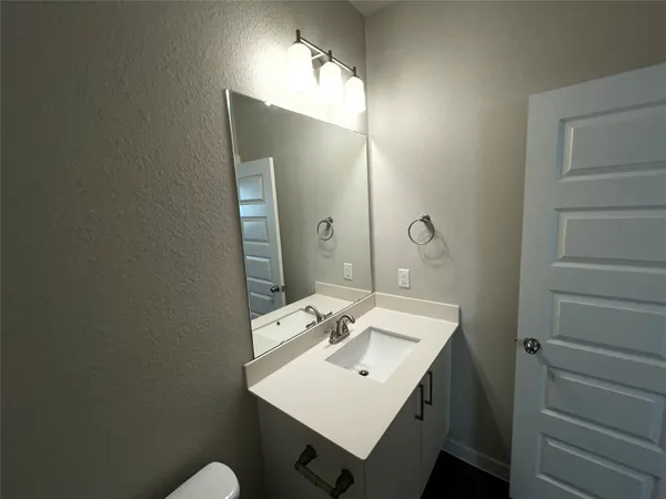 a bathroom with a sink toilet and mirror