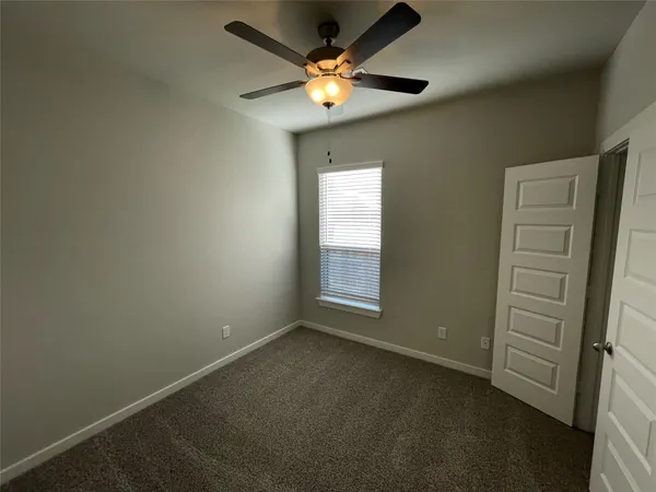 an empty room with closet and a chandelier fan