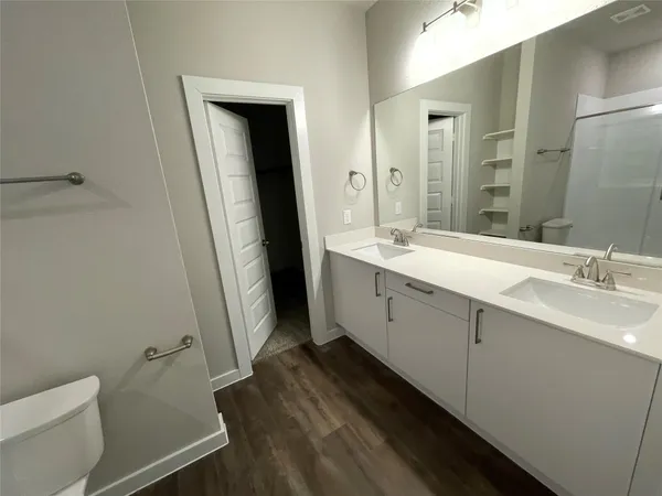 a spacious bathroom with a double vanity sink and mirror