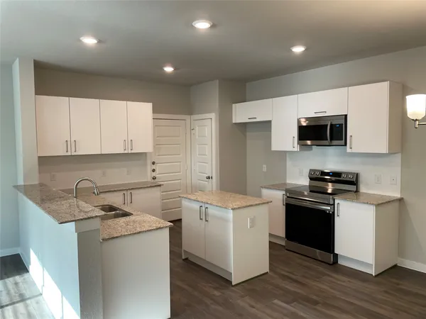 a kitchen with a sink stove top oven and cabinets