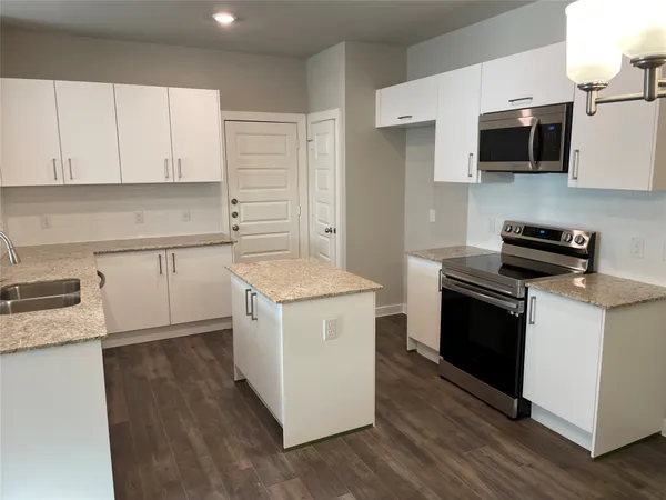 a kitchen with a sink stove and microwave