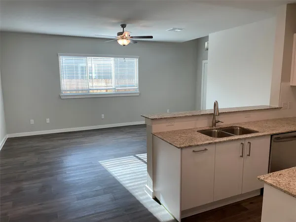 a kitchen with stainless steel appliances granite countertop a sink stove and wooden floor