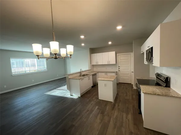 a kitchen with a wooden floor and white appliances