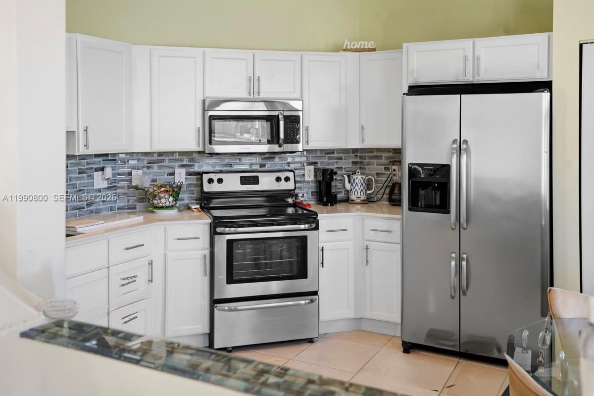 337 Southwest Maclay Way Port St. Lucie, FL 34986 - Photo 16 of 52 a kitchen with stainless steel appliances a refrigerator stove and microwave