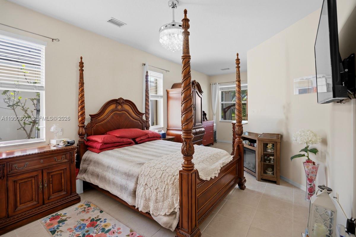 337 Southwest Maclay Way Port St. Lucie, FL 34986 - Photo 19 of 52 a bedroom with a bed a flat screen tv and dresser