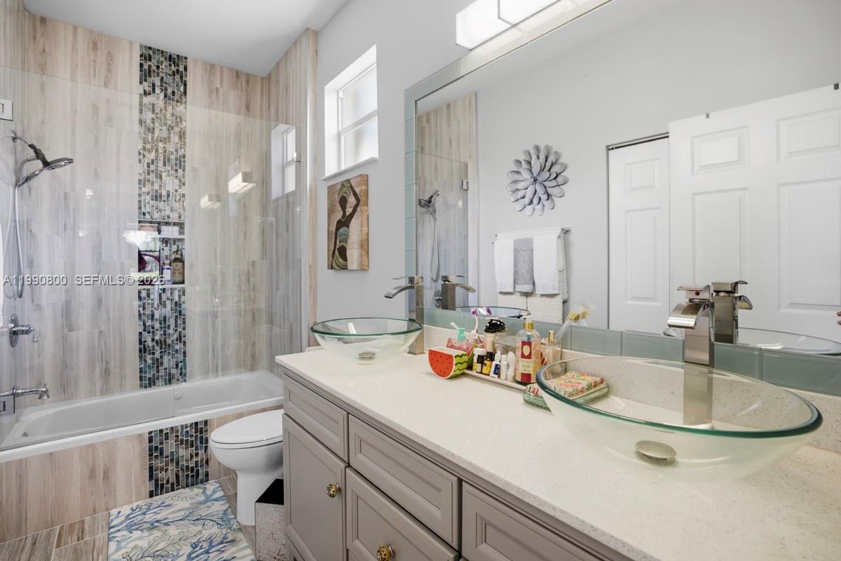 337 Southwest Maclay Way Port St. Lucie, FL 34986 - Photo 2 of 52 a bathroom with a sink double vanity and a toilet