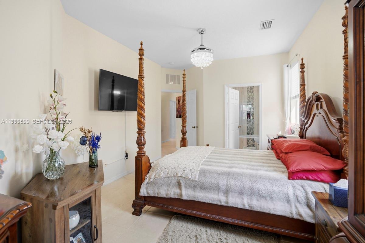 337 Southwest Maclay Way Port St. Lucie, FL 34986 - Photo 21 of 52 a bedroom with a bed and flat screen tv