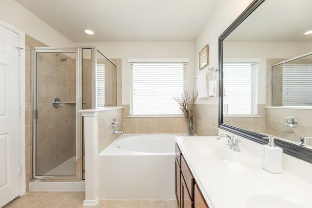 a white bath tub sitting in a bathroom next to a window