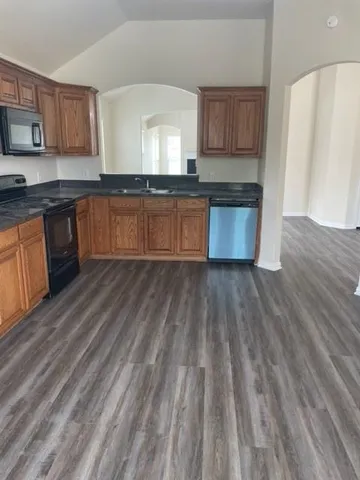 a large kitchen with wooden floors and wooden cabinets
