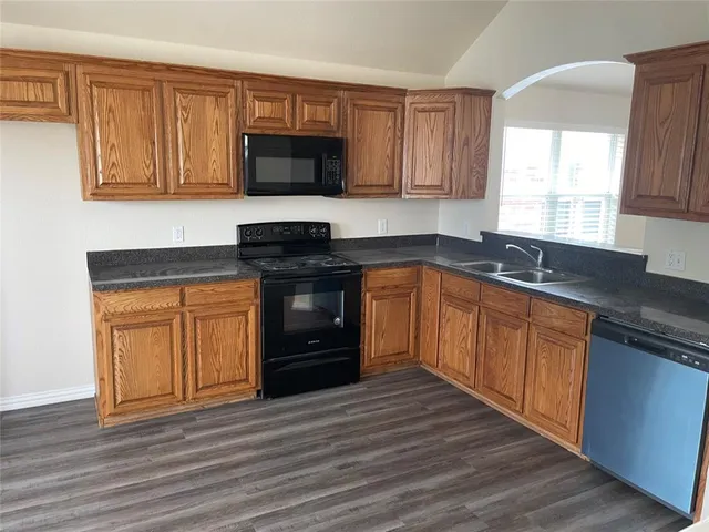a kitchen with a sink stove top oven and cabinets