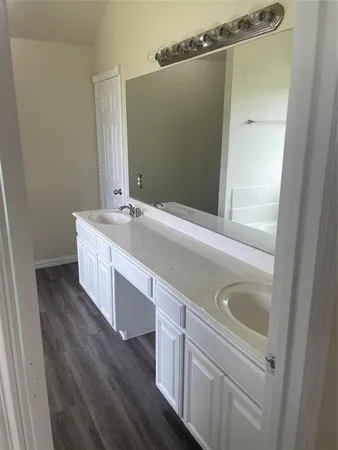 a bathroom with a double vanity sink and mirror with shower