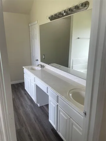 a bathroom with a double vanity sink and mirror with shower