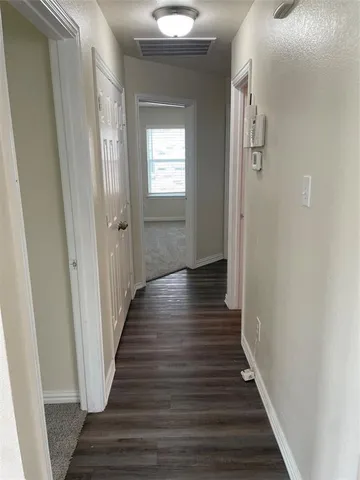 a view of a hallway with wooden floor