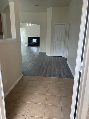 a view of a hallway to room with wooden floor