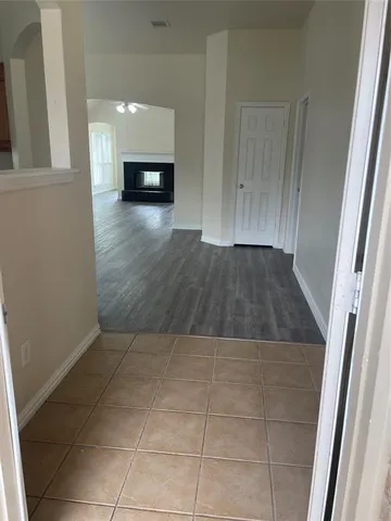 a view of a hallway to room with wooden floor