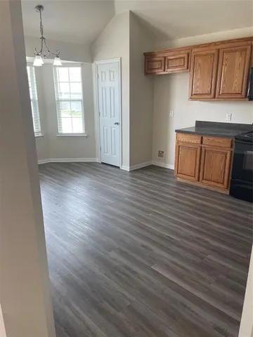 a view of a kitchen with wooden floor and windows