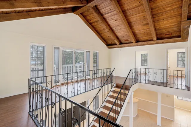 an empty room with wooden floor and a ceiling fan