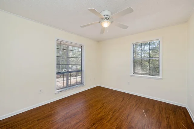 an empty room with a window and wooden floor