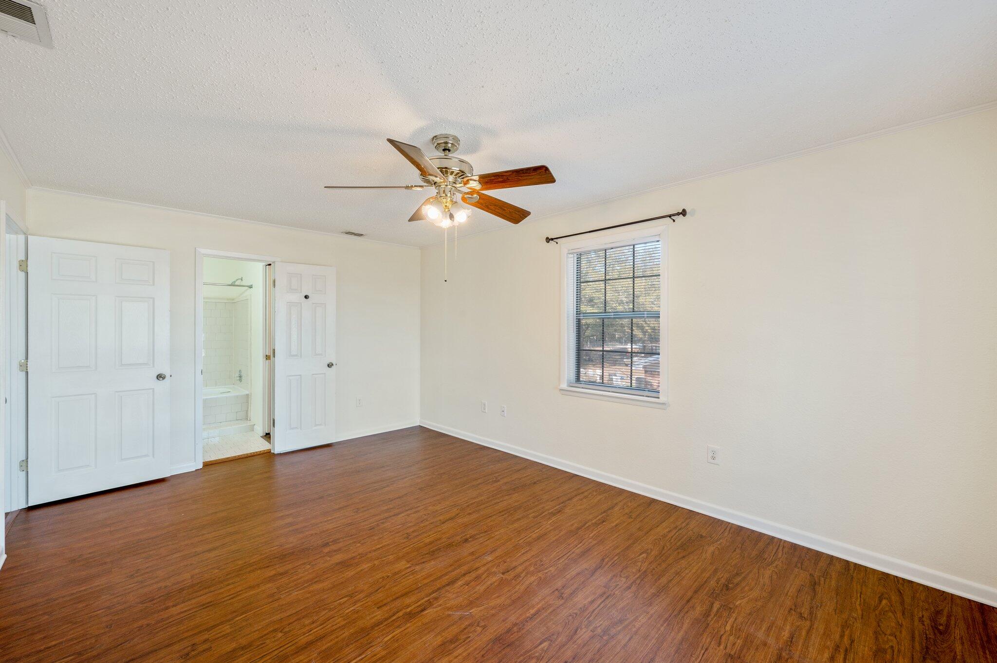 770 Lakeview Drive DeFuniak Springs, FL 32433 - Photo 31 of 32 an empty room with wooden floor ceiling fan and windows