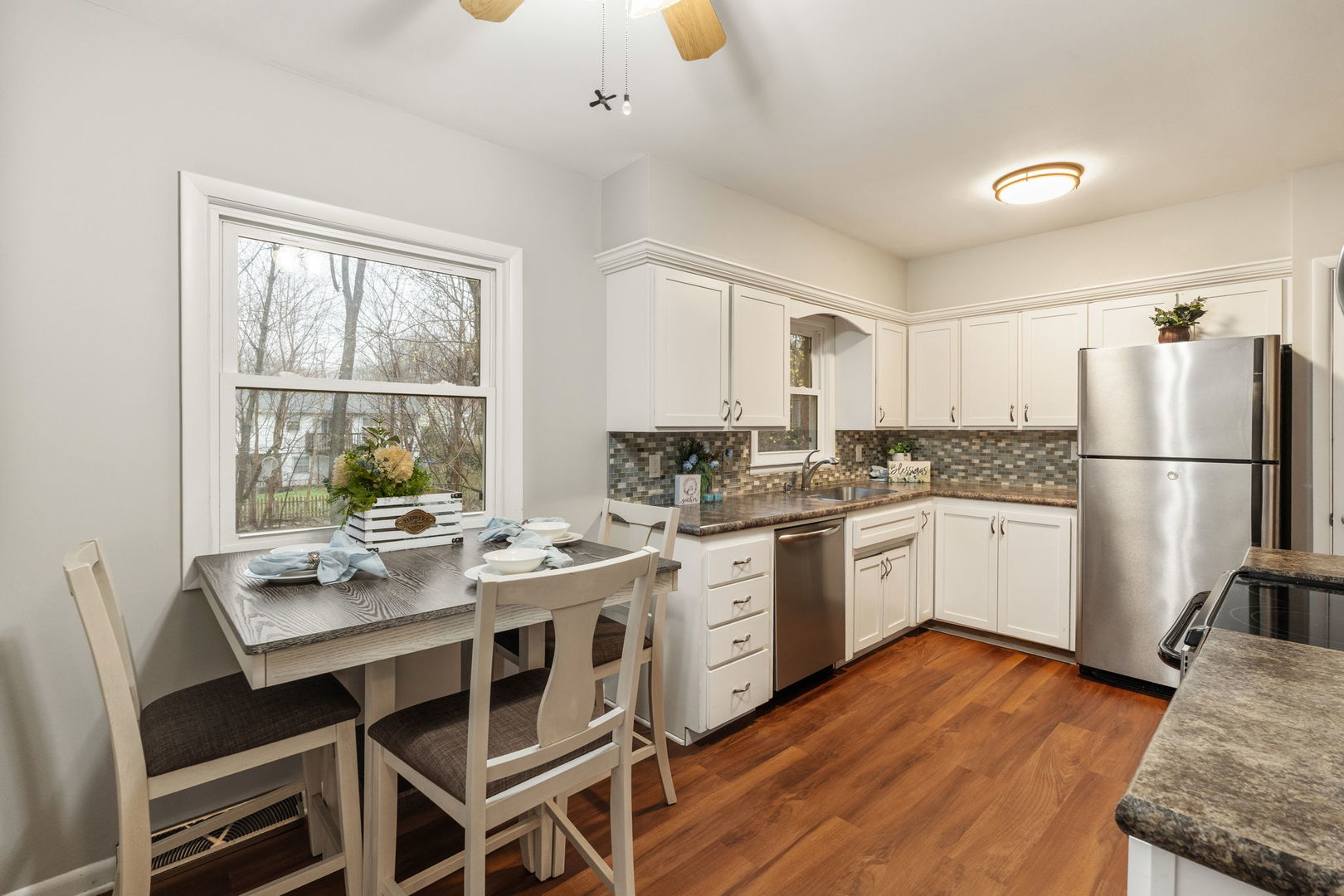 3103 15th Street A Moline, IL 61265 - Photo 10 of 33 a kitchen with stainless steel appliances granite countertop a stove a refrigerator a sink dishwasher and white cabinets with wooden floor