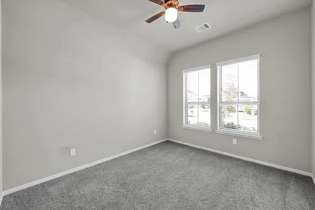 an empty room with a window and a fan