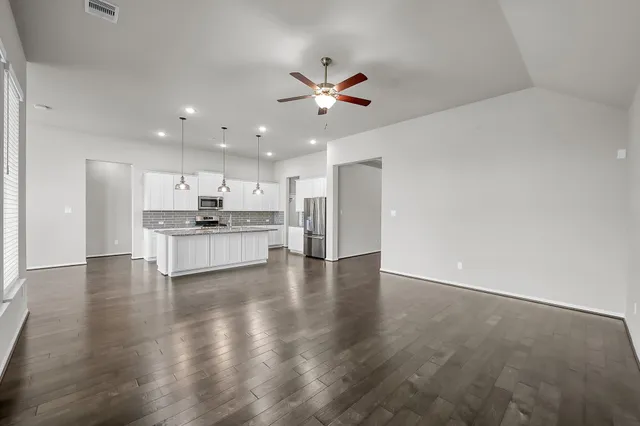 a view of an empty room with kitchen appliances and a kitchen view