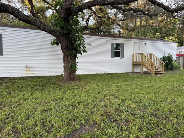a white house that has tree in front of it