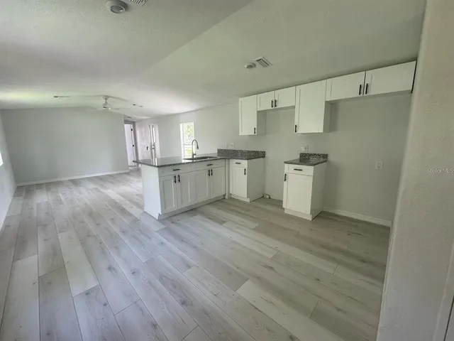 a kitchen with a wooden floor and white appliances
