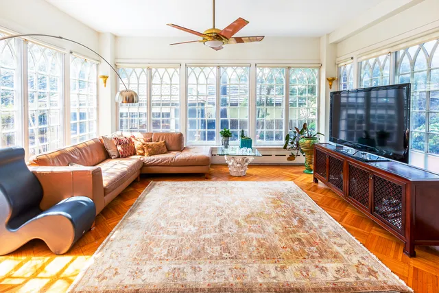 a living room with furniture a flat screen tv and a large window