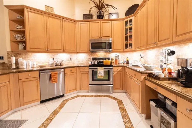 a kitchen with stainless steel appliances granite countertop a sink and cabinets