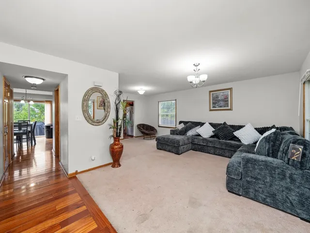 a living room with furniture a mirror and lamp